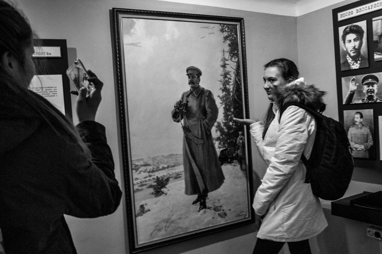 Школьница фотографируется на фоне портрета Иосифа Сталина.